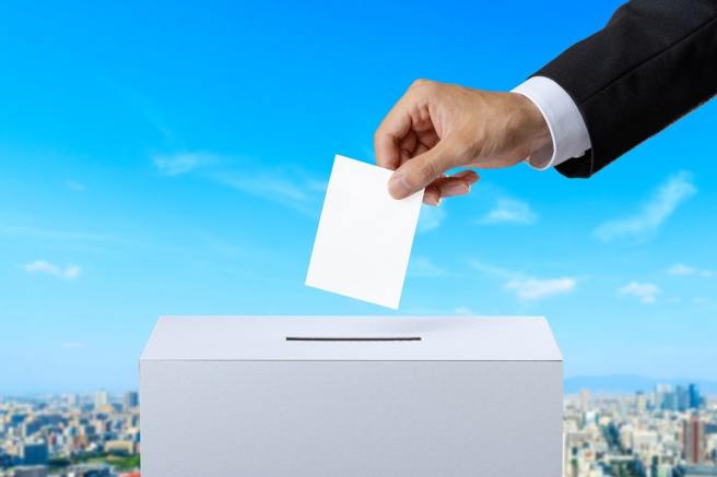 投票する背広姿の男性